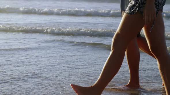 Couple walking together on shore at beach