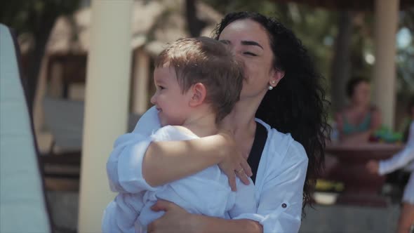 Happy Mother Hugging Her Child on the Coast