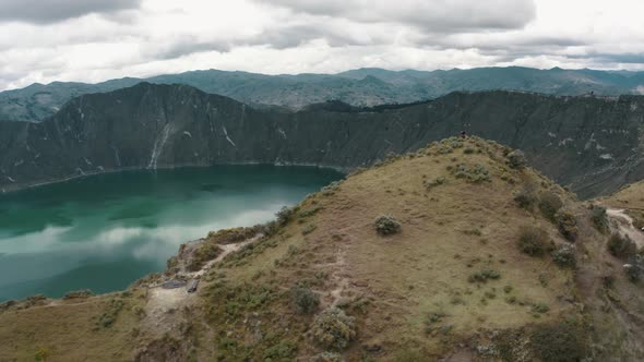 Aerial drone shot showing tremendous crater lake surrounded by volcano landscape and mystic clouds a