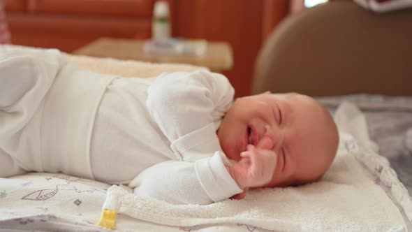 a Newborn Baby Cries on a Diaper Mother's Hands Take Him Away