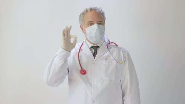 Portrait of Medical Doctor With Protective Mask and protective gloves doing OK sign with finger 4K