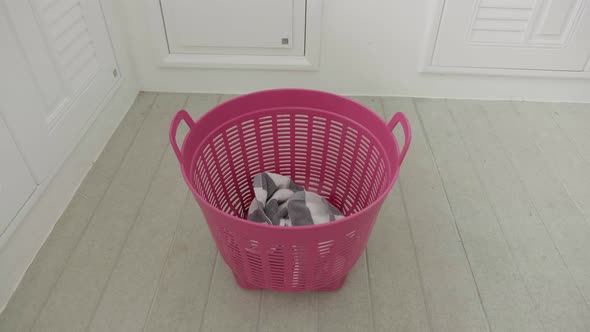 Slow Motion of Clothes Pants Filling Into a Laundry Basket on a Floor