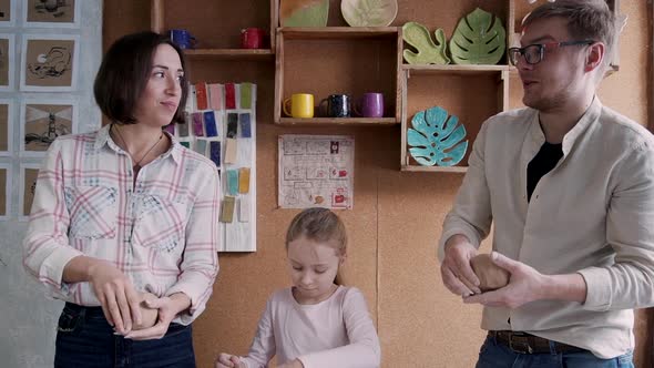 Little Girl with Adult Mother and Father Working with Raw and We