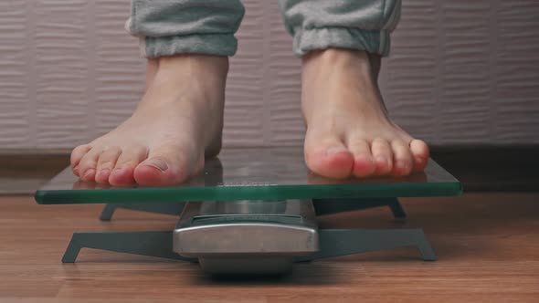 Women's Feet Stand on the Scales and Check Their Kilograms Front View