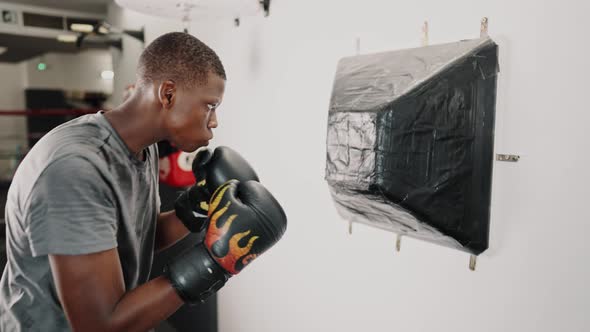 Young Focused African Man Boxer Practicing Punches While Training in Fight Club