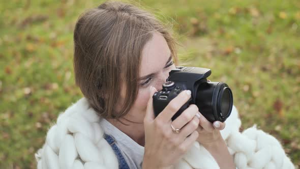 The Girl Takes Pictures of Nature in the Park in the Summer