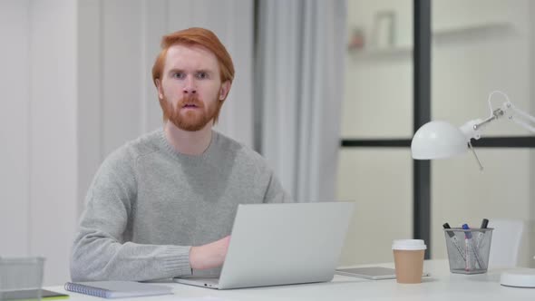 Beard Redhead Man Feeling Shocked While Using Laptop