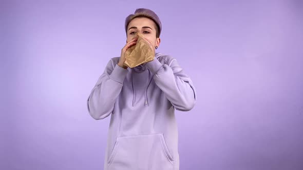 Young Woman Having Panic Attack Breathing Using Paper Bag Isolated