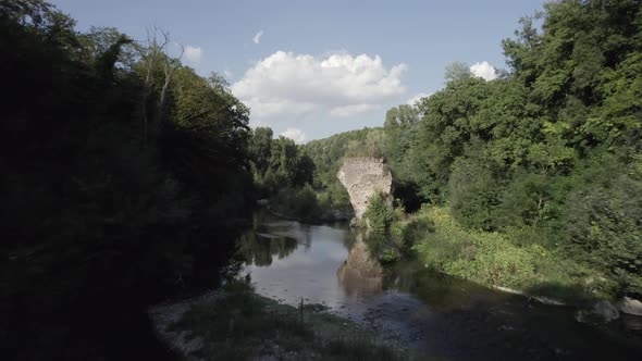 -SHOT: through, Sam Kolder-DESCRIPTION: drone video over the Fiora river passing between a bridge v