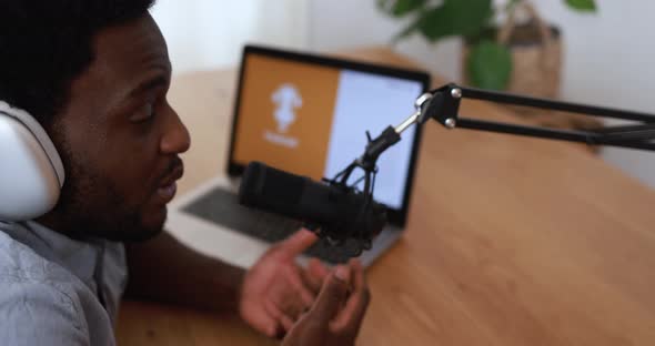 Young african man doing podcast using computer laptop at home - Technology trend concept
