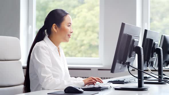 Asian business woman is working at her table in a modern office.
