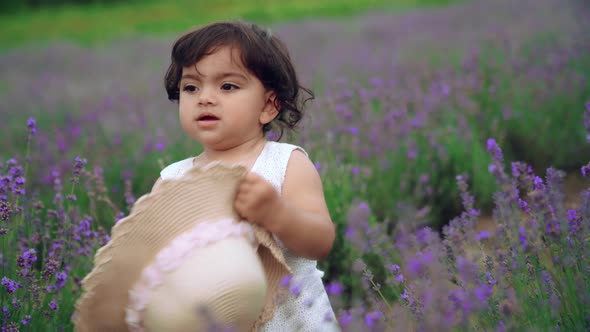 Baby Girl Carrying Straw Hat in Lavender Field