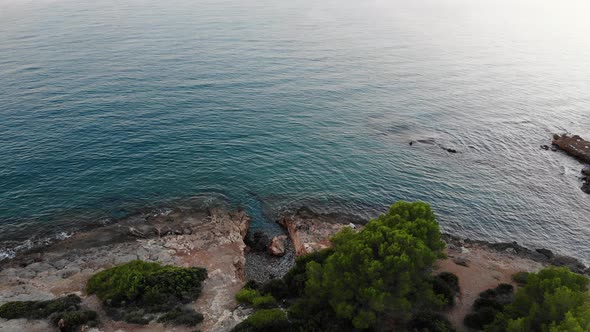 Beautiful view at 4k of cliff that ends in a calm sea of ​​the Mediterranean, the wind draws silhoue