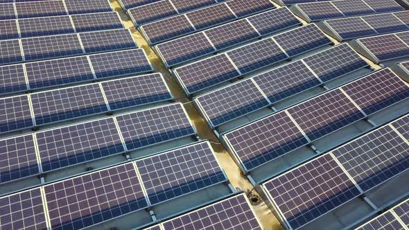 Aerial View of Many Photo Voltaic Solar Panels Mounted of Industrial Building Roof