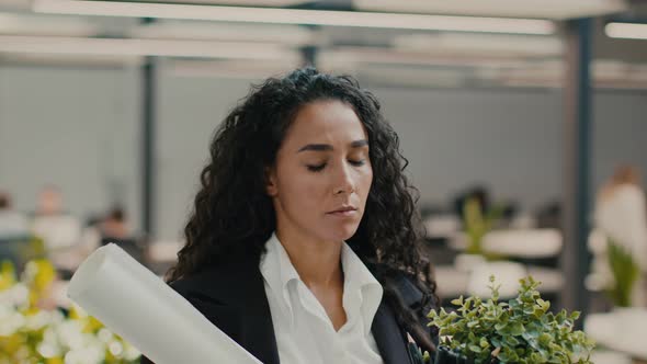 Fired Female Employee Walking With Cardboard Box Leaving Office