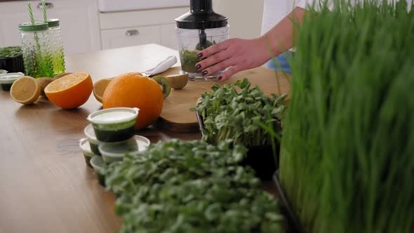 Closeup of a Woman Whipping Up Microgreens and Fresh Fruit in a Blender