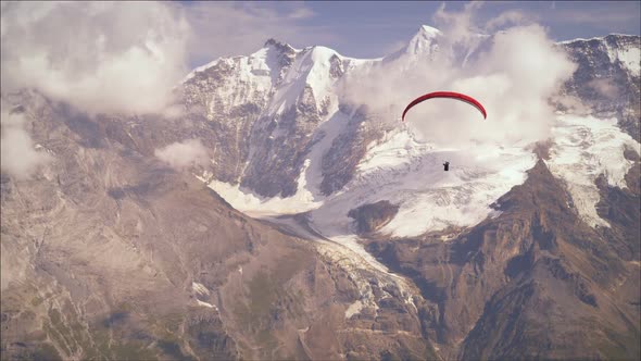 Shot of a paraglider passing the Swiss alps