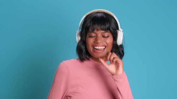 Woman in Wireless Headphones Dances and Sings Into an Imaginary Microphone