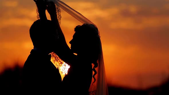 Bride and Groom Are Kissing at Sunset.