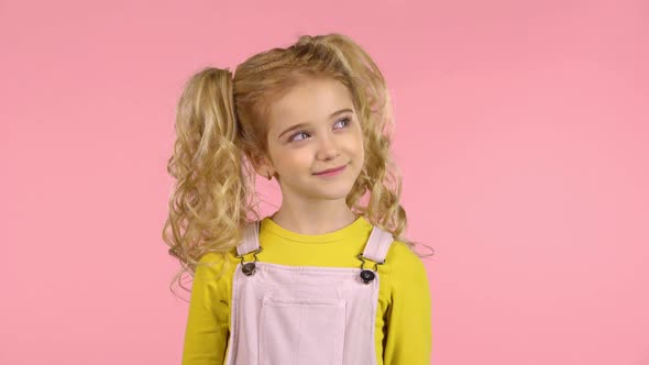 Little Female Cutie in Studio on Pink Background with Thoughtful and Smiling Face