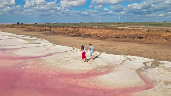 Lovely Young Couple Walking Along Beautiful Pink Lake with Salty Shore