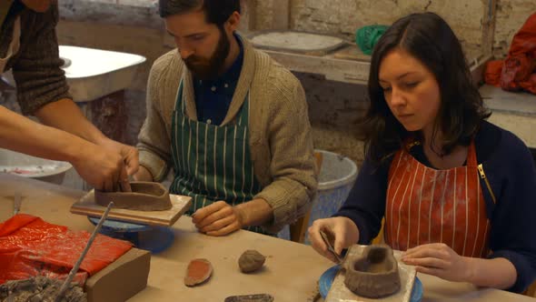 Potter teaching his colleagues to mold the clay