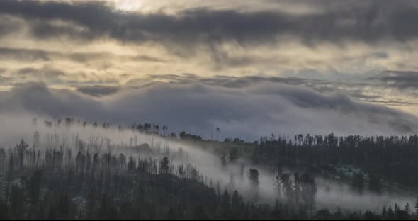 Timelapse of Evening Sun Rays Emerging Through the Cold Foggy Clouds in the Mountains