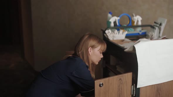 Housekeeper taking staple of towels from cleaning cart