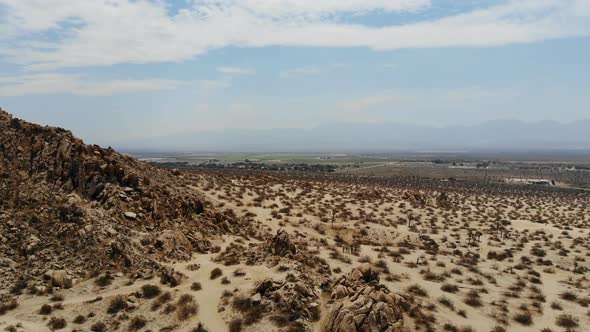 Aerial shot flying over a desolate dry desert landscape on a scorching hot day in summer