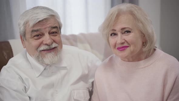 Close-up of Elderly Caucasian Man and Woman Looking at Each Other, Turning To Camera and Smiling