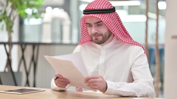Hardworking Arab Businessman Reading Documents in Office
