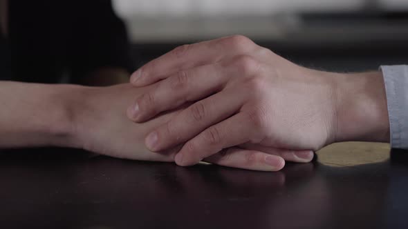 Close-up of Male Caucasian Hands Holding Each Other. Unrecognizable Gay Couple Expressing Love. Care