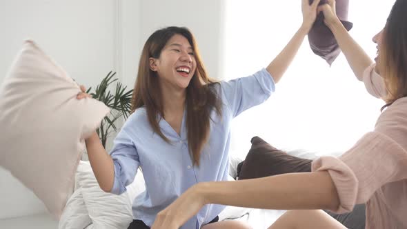 Asian young lesbian couple playing to each other with love moment on the sofa in bedroom.