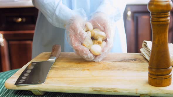 The Chef Puts Champignon Mushrooms on the Cooking Table