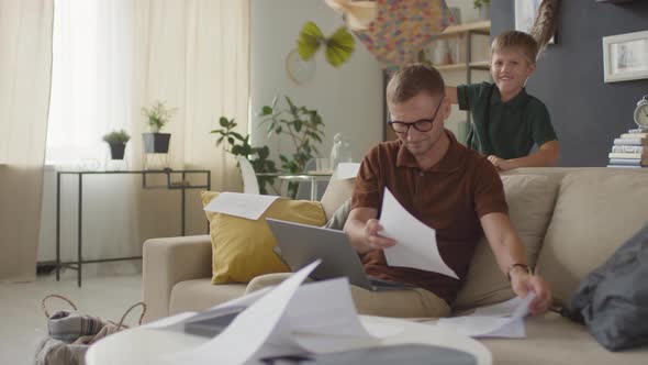 Boy Preventing Father From Work