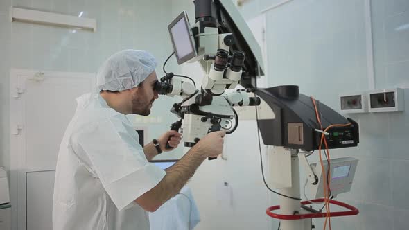 Doctor  Loking at Monitor at Big Microscope System in a Hospital Laboratory