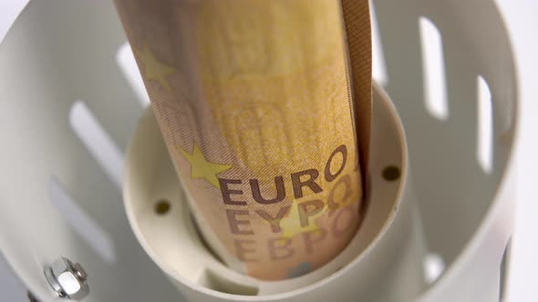 Euro banknote in an electric lamp holder. Macro