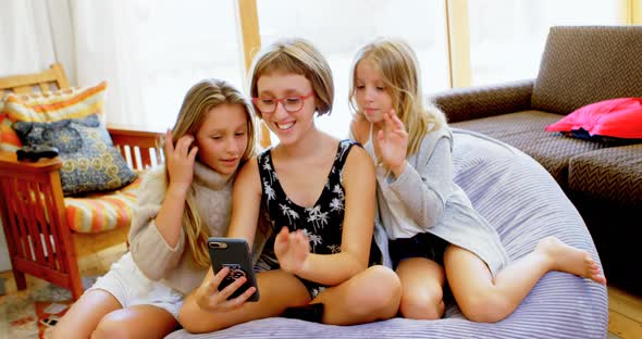 Siblings taking selfie with mobile phone in living room 4k