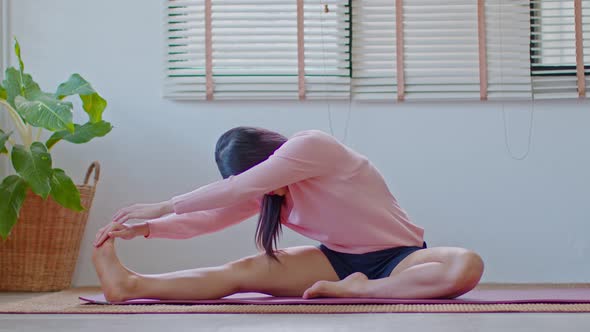 Asian woman in casual stretching muslce to warm up breathing and meditation with yoga