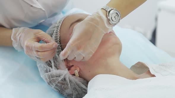 Cosmetician Gloves Making Face Lifting Injection To Area Around Eyes