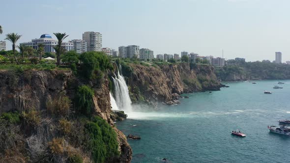 aerial drone passing a cliff revealing the waters of the Lower Duden Waterfall drop off a rocky clif