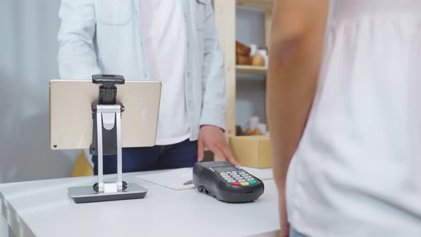 Close up hands of young man use credit card pay for vase goods order.