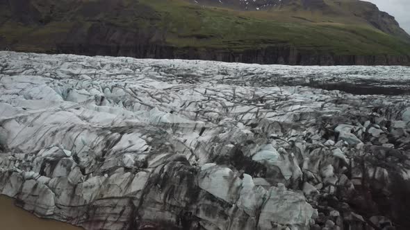 Iceland glacier close up with drone video moving down to water.