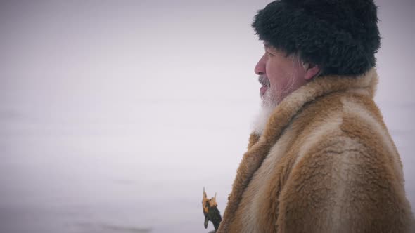 Side View Portrait of Senior Bearded Man Walking at Background of Frozen Northern Ocean