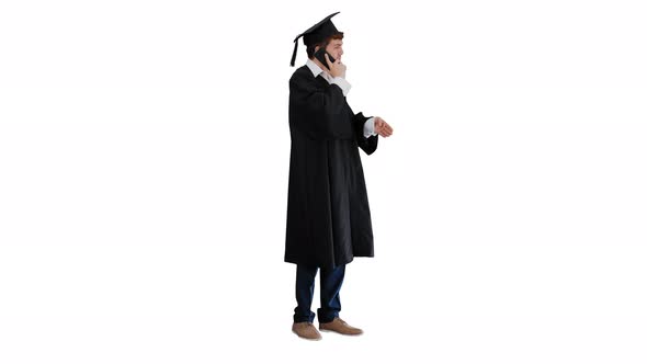 Male Graduate in Gown and Mortarboard Having Conversation on the Phone on White Background.