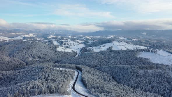 Aerial view on the road and forest in the winter time. Natural winter landscape from air