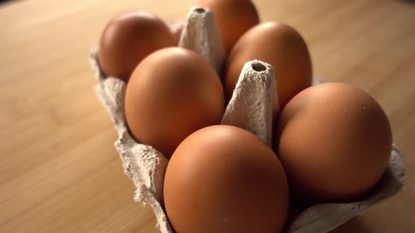 close up of brown eggs in egg carton on rustic background