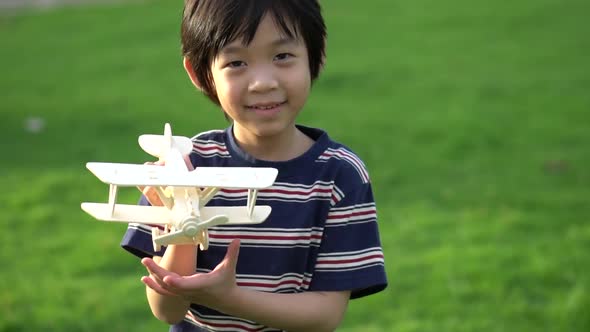 Cute Asian Child Playing Wooden Airplane In The Park Outdoors Slow Motion 