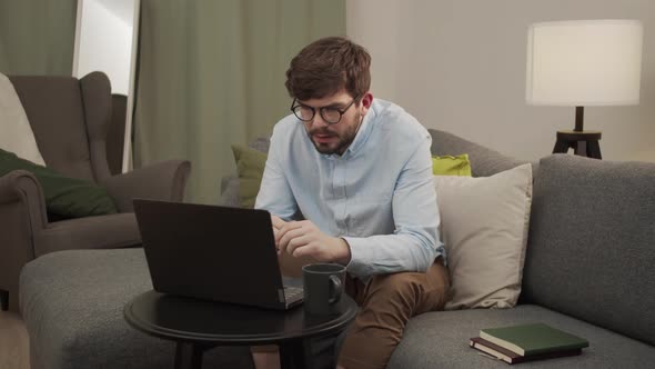 A European Man Puts on Glasses and Talks in a Video Link