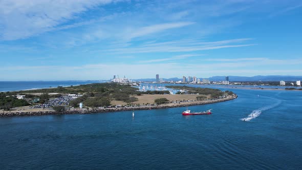 Large sand dredging vessel positioned in a busy ocean inlet for a coastal rejuvenation project with